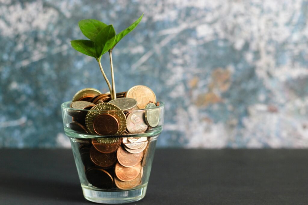 copo com planta e moedas. Planos de Previdência