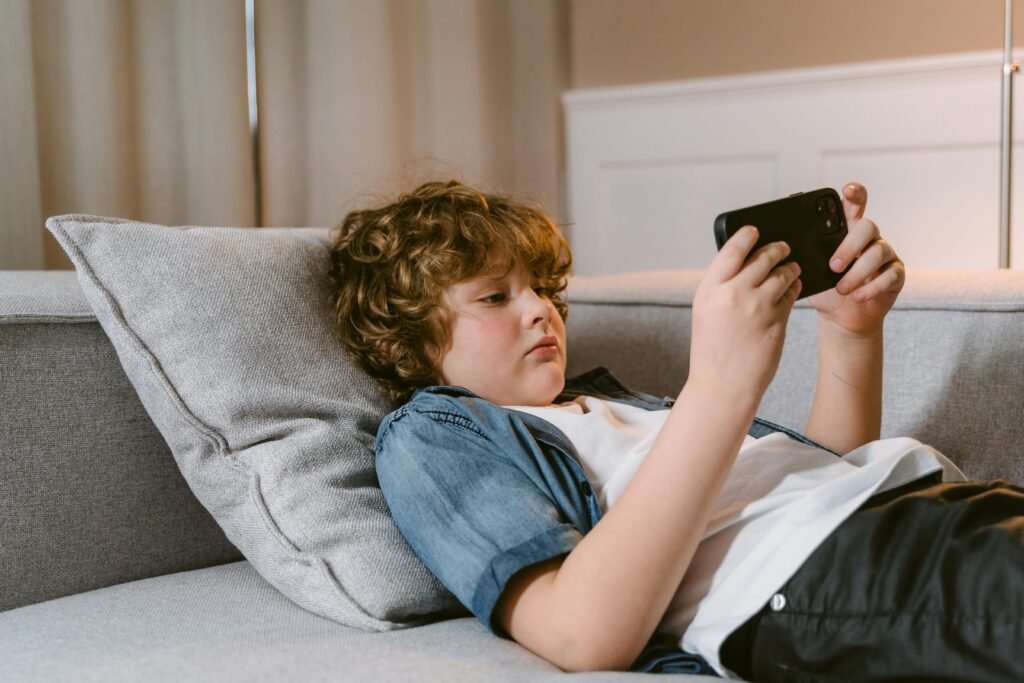 Menino assistindo no celular- Como ativar o controle parental no YouTube
