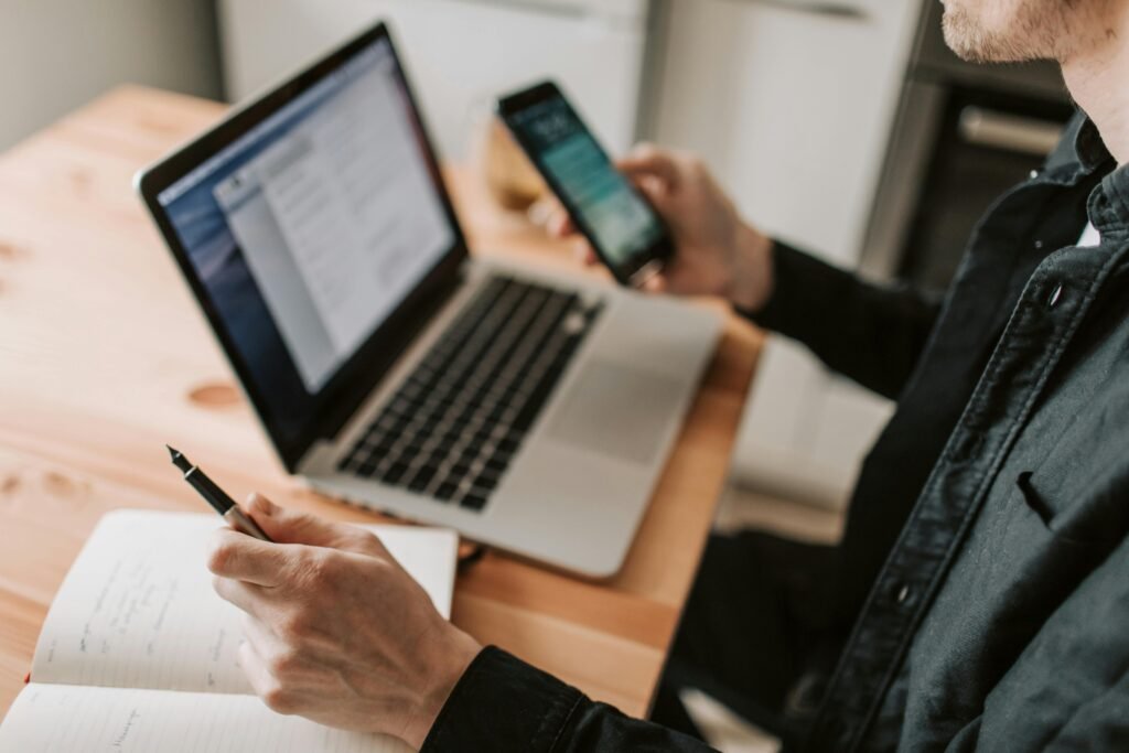 Pessoa com celular e notebook. Respostas Automáticas no WhatsApp Business – Como Configurar